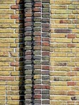 Een verticale strook donkere bakstenen markeert de beide woonhelften.
              <br/>
              Gert-Jan Lobbes, 2019